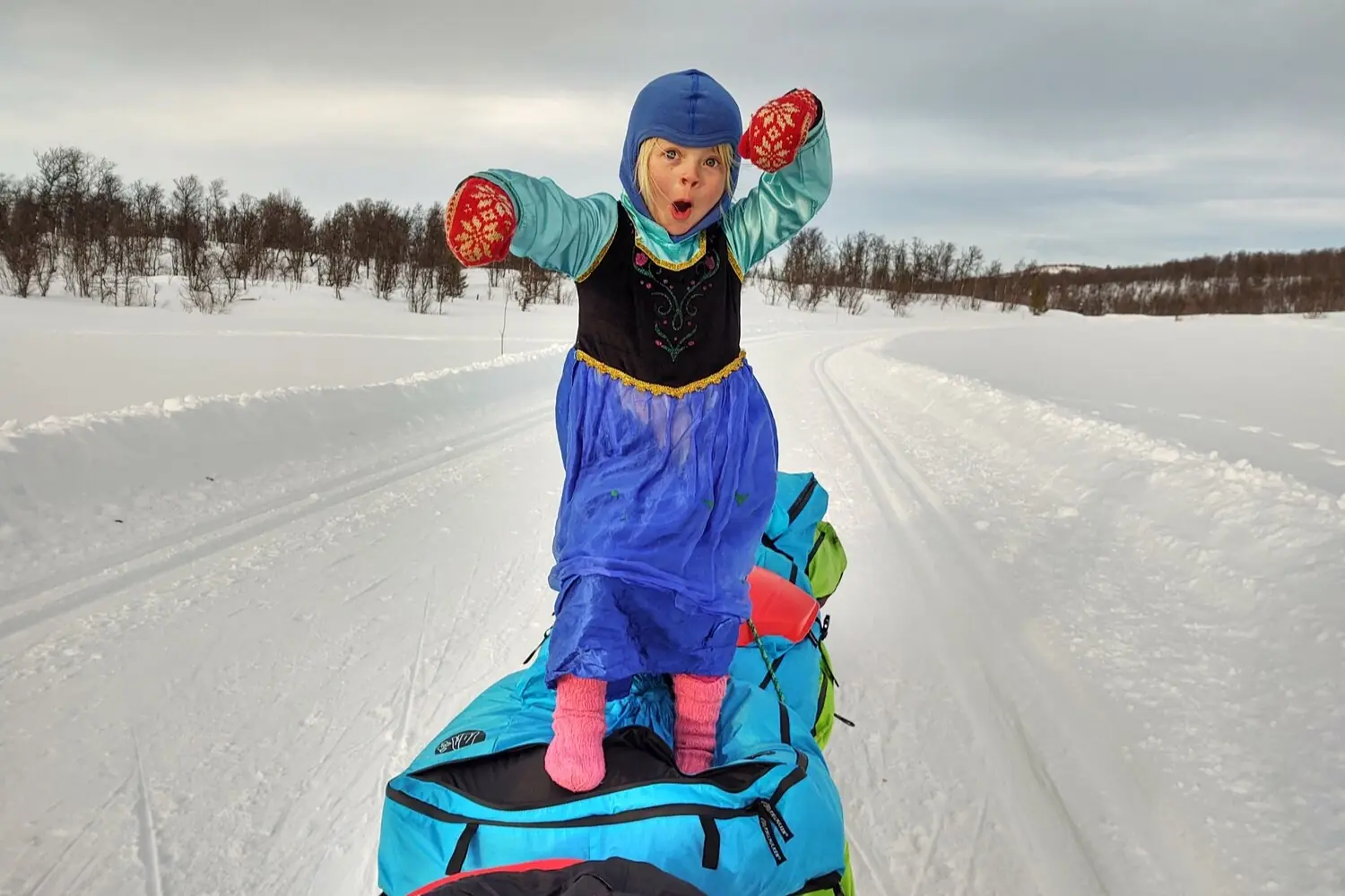 Mina on a pulk playing in the snow