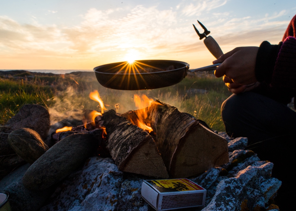 frying pan over a campfire in the sunset