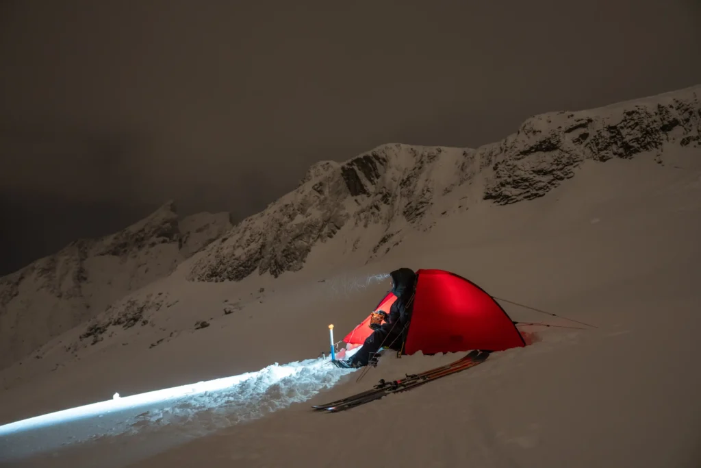 person koser seg med real turmat i fjell og vinterlandskap