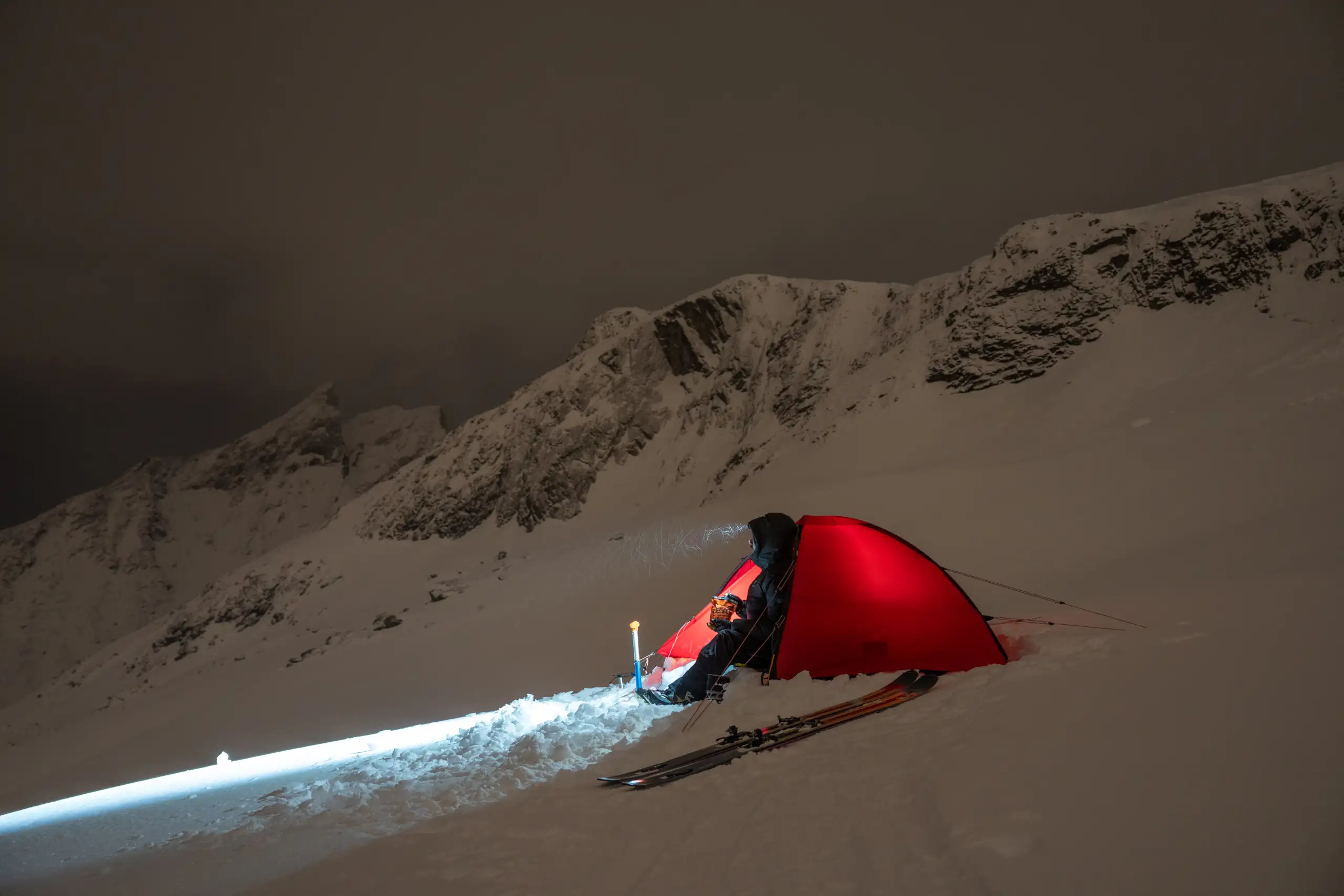 person koser seg med real turmat i fjell og vinterlandskap